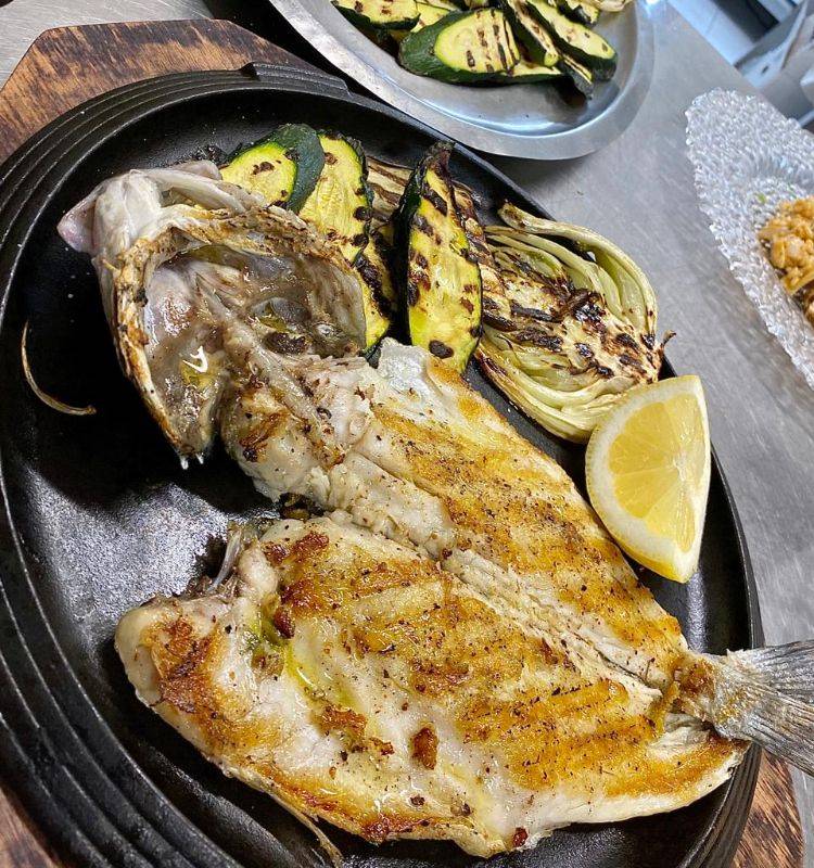 Branzino/ o Orata sfilettato a portafoglio grigliato servito su piastra calda con verdure grigliate